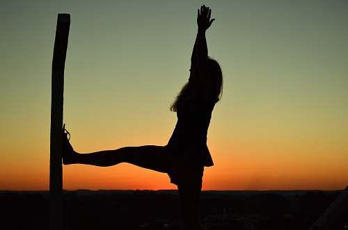 dance pose silhouette of woman doing yoga during golden hour leisure activities